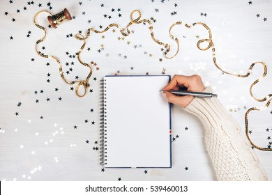 Holiday decorations and opened notebook on white rustic table, flat lay style. Christmas planning concept.
