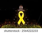 Holiday display with a giant lit up yelow ribbon statue representing the hostages being held in Gaza by Hamas with the Bahai Temple in the background in the German Colony in Haifa, Israel
