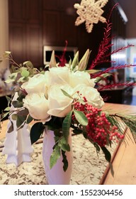 Holiday Floral Center Pieces With White Roses, Red Accents And Greenery On A Large Butcher Block And White Granite Kitchen Island