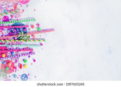 Holiday frame or background with colorful straws, confetti and hard candy. Birthday or party greeting card flat lay with copy space. - Powered by Shutterstock