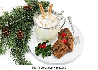 Holiday Fruitcake And Eggnog On A Plate Garnished With Holly And Surrounded By Pine Branches.  White Background.