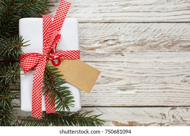 Holiday Gift Box. Christmas Present With Tag At White Wooden Table.