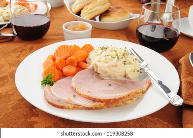 A Holiday Ham Dinner With Mashed Potatoes And Red Wine