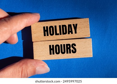 Holiday hours message written on wooden blocks on blue background. Conceptual holiday hours symbol. Copy space. - Powered by Shutterstock