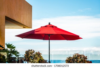 A holiday image. Single red umbrella against a tropical sky and seascape - isolated. copy space, background.