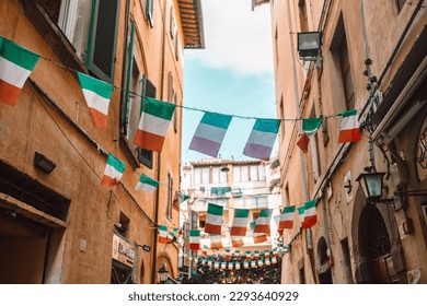 Holiday in the Italian city of streets with Italian flags and ancient buildings. Pisa, Italy. High quality photo