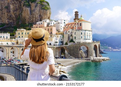 Holiday in Italy. Back view of young woman with white dress and hat looking the village of Atrani on Amalfi Coast, Italy.
