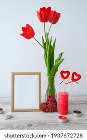 Holiday Mock Up. Tulip Flowers In Glass Vase With Picture Frame Decor On Wooden Table Background Wall At Home, Close Up, Mothers Womans Valentines Day Design Concept.