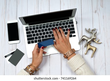 Holiday Online Shopping Concept. Woman holding credit card and using laptop computer. - Powered by Shutterstock