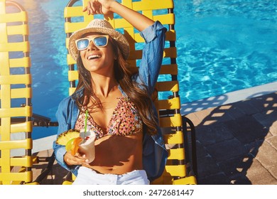 Holiday, pool and woman sitting on chair for relax in sunshine, cocktail at hotel in summer. Female person, vacation or wellness in Mauritius with smile for travel, blue sky on tropical island - Powered by Shutterstock