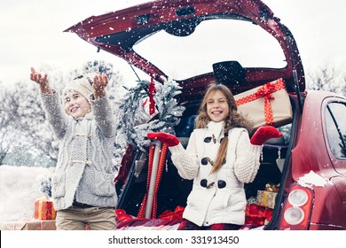 Holiday Preparations. Pre Teen Children Enjoy Many Christmas Presents In Car Trunk. Cold Winter, Snow Weather.