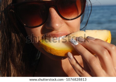 Holiday, resort, tourism concept - Summer vacation - young girl eating fresh watermelon on sandy beach. young beautiful woman eats watermelon on the beach at hot summer day.