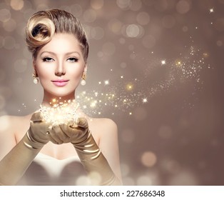 Holiday Retro Woman With Magic In Her Hand. Beauty Fashion Christmas Vintage Style Lady With Beautiful Luxury Hairstyle, Makeup, Accessories. Golden Silk Gloves And Dress 