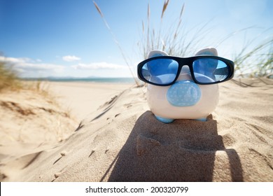 Holiday Savings Piggy Bank On A Beach Vacation With Sunglasses