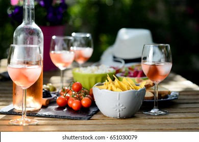holiday summer brunch party table outdoor in a house backyard with appetizer, glass of rose wine, fresh drink and organic vegetables   - Powered by Shutterstock