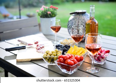 Holiday Summer Brunch Party Table Outdoor In A House Backyard With Appetizer, Glass Of Rosé Wine, Fresh Drink And Organic Vegetables  