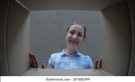 Holiday, Unpacking, Unboxing, Birthday, Celebration, Emotions, Surprise Concept. Happy Positive Woman In Plaid Shirt Opening Cardboard Box With Gift, Looking Inside And Smiling - Pov Low Angle View