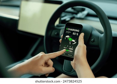 Holiday vacation road trip with environmental-friendly car concept. Eco-conscious woman on driver seat checking EV car's battery status display on smartphone during car travel. Perpetual - Powered by Shutterstock