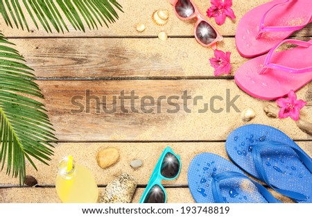 Holiday (vacation) tropical beach background layout with free text space. Palm tree leaves, sand, exotic flowers, sunglasses and flip flops on vintage wood - poster design.