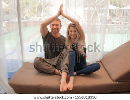 holiday yoga retreat portrait of young happy and beautiful hipster couple sitting in lotus position together enjoying zen lifestyle smiling cheerful and relaxed in wellness balance and harmony 