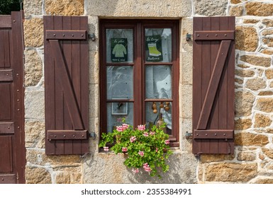 Holidays in Brittany, France: A beautiful old window of a typical Breton stone house with flowers and shutters - funny text means 