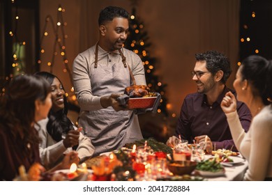 holidays and celebration concept - multiethnic group of happy friends having christmas dinner at home - Powered by Shutterstock