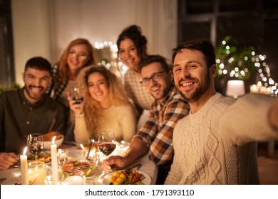 holidays, celebration and people concept - happy friends taking selfie at home christmas dinner party - Powered by Shutterstock