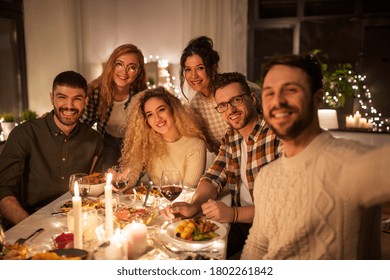 holidays, celebration and people concept - happy friends taking selfie at home christmas dinner party - Powered by Shutterstock