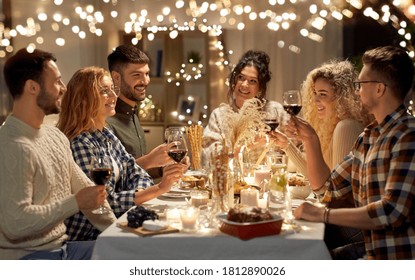 holidays, celebration and people concept - happy friends having christmas dinner at home drinking non-alcoholic red wine - Powered by Shutterstock