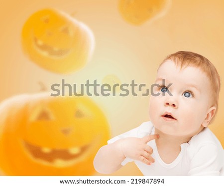 Foto Bild Happy Halloween.überrascht Kind in einem Skelett-Kostüm mit Popcorn gegen orange Hintergrund