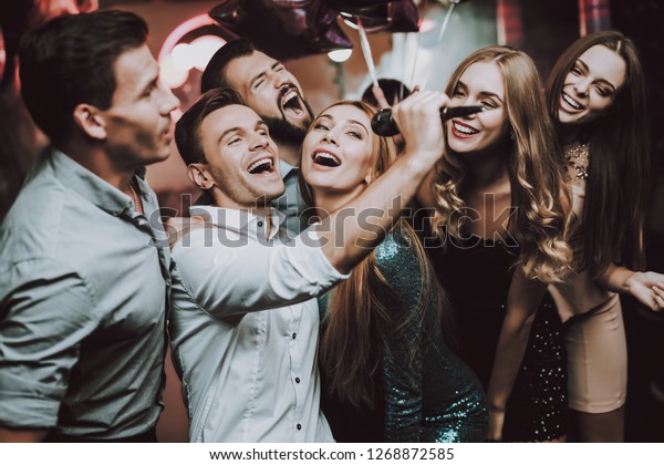 Holidays\
Concept. Dancing People. Great Mood. Young People. Dance Club.\
Sing. Microphone. Trendy Modern Nightclub. Party Maker. Birthday.\
Karaoke Club. Celebration. Men. White\
Shirt.