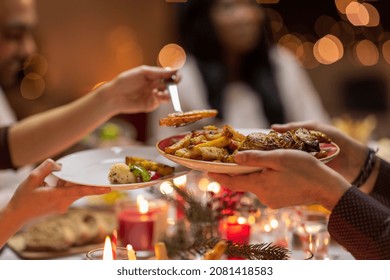 holidays, eating and celebration concept - close up of friends having christmas dinner at home and sharing food