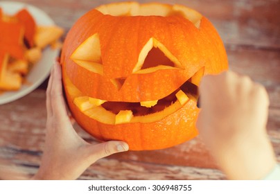 holidays, halloween, decoration and people concept - close up of woman with pumpkins at home - Shutterstock ID 306948755