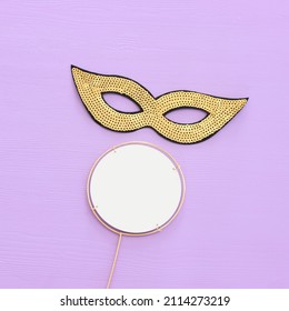 Holidays image of mardi gras masquarade sequins mask over purple background. view from above