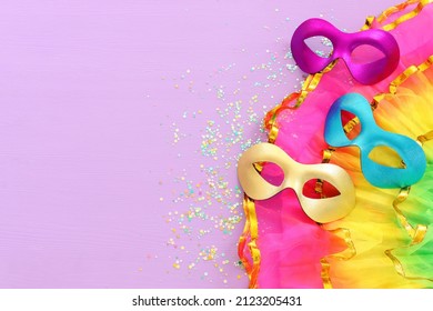 Holidays image of mardi gras masquarade masks over purple background. view from above