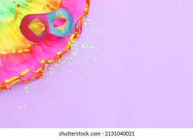 Holidays image of mardi gras masquarade mask over purple background. view from above