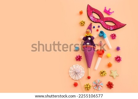 Holidays image of mardi gras masquarade mask and streamers over pastel background. view from above