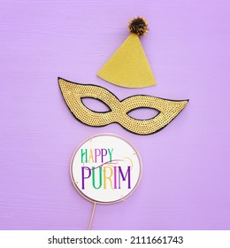 Holidays image of masquarade sequins mask over purple background. view from above. Purim celebration