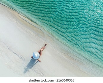 Holidays in the Maldives. Paradise tropical beach. Woman on the background of the sea and sunny beach. Travel, tourism and relaxation - Shutterstock ID 2163649365