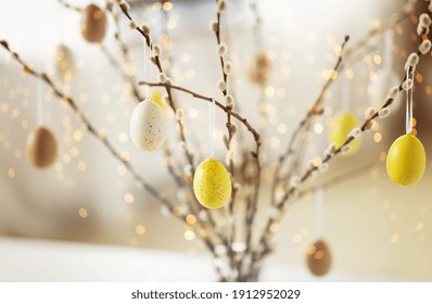 holidays and object concept - close up of pussy willow branches decorated by easter eggs over bokeh lights - Shutterstock ID 1912952029