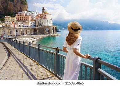 Holidays on Amalfi Coast. Back view of beautiful fashion girl enjoying view of Atrani village on Amalfi Coast. Summer vacation in Italy.