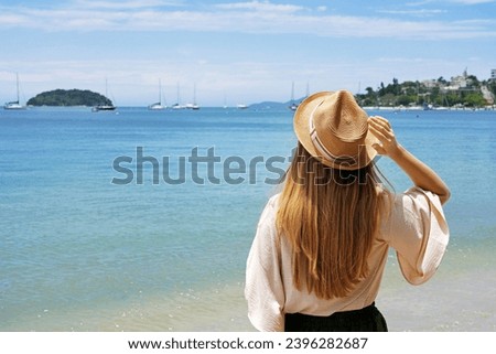 Holidays on tropical island. Traveler girl on Jurere beach, Florianopolis, Santa Catarina Island, Brazil.