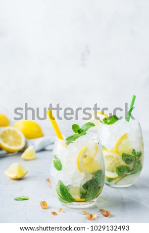 Holidays and party, food and drink concept. Cold alcohol mojito cocktail, long drink beverage, lemonade with lemon, mint and ice in a glass on a table. Copy space background