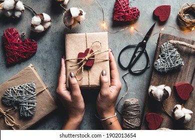 holidays, people and celebration concept - close up of woman decorating valentine presents