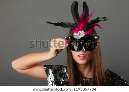Holidays, people and celebration concept. Closeup woman face with carnival venetian mask sequin evening dress on gray background.