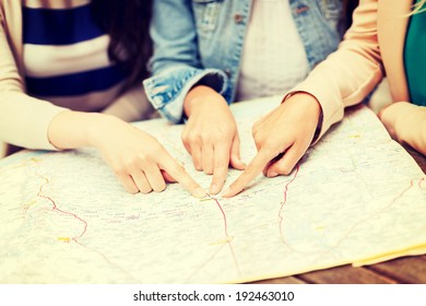 holidays and tourism concept - women with tourist map in the city