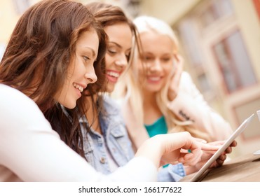 Holidays, Tourism, Technology And Internet - Three Beautiful Girls Looking At Tablet Pc Computer In Cafe Outside