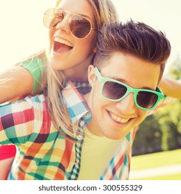 Holidays, Vacation, Love And Friendship Concept - Smiling Teen Couple In Sunglasses Having Fun In Summer Park