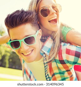 Holidays, Vacation, Love And Friendship Concept - Smiling Teen Couple In Sunglasses Having Fun In Summer Park