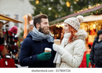 Holidays, Winter, Christmas, Hot Drinks And People Concept - Happy Couple Of Tourists In Warm Clothes Drinking Coffee From Disposable Paper Cups In Old Town